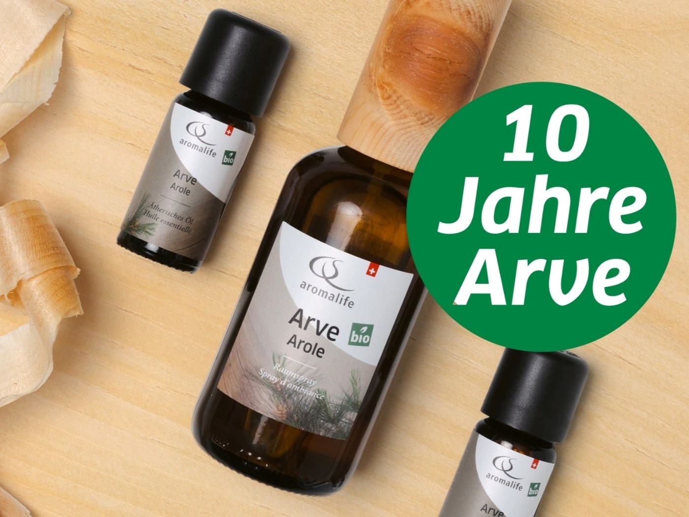 Arve ätherisches Öl und Arve Raumspray liegen auf einem Tisch aus Arvenholz